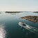 A 2 level boat sailing through waters dotted with islets and islands